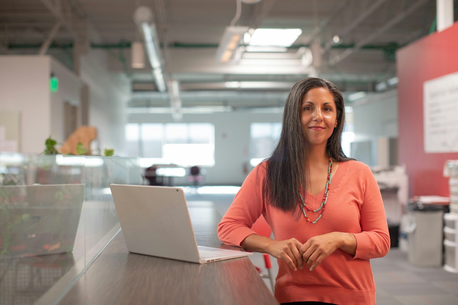 Woman working at a table with a laptop, focused on her career growth