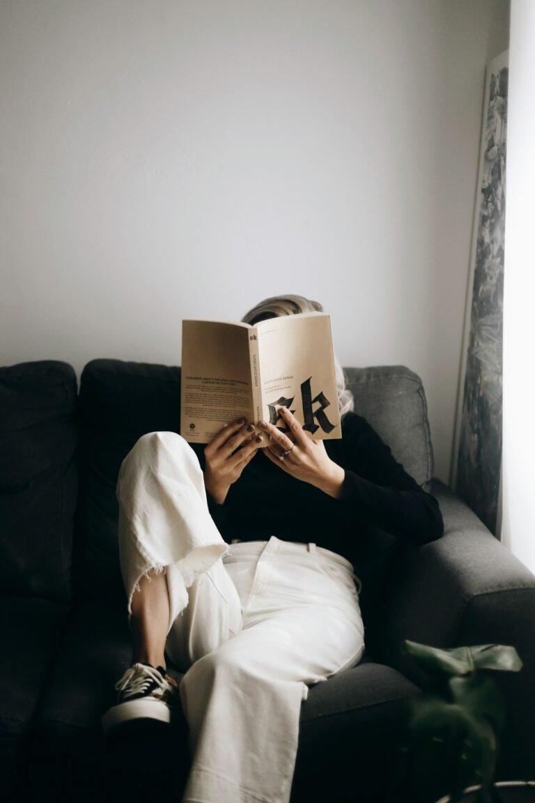 Woman reading a book on a sofa for a comfortable night in
