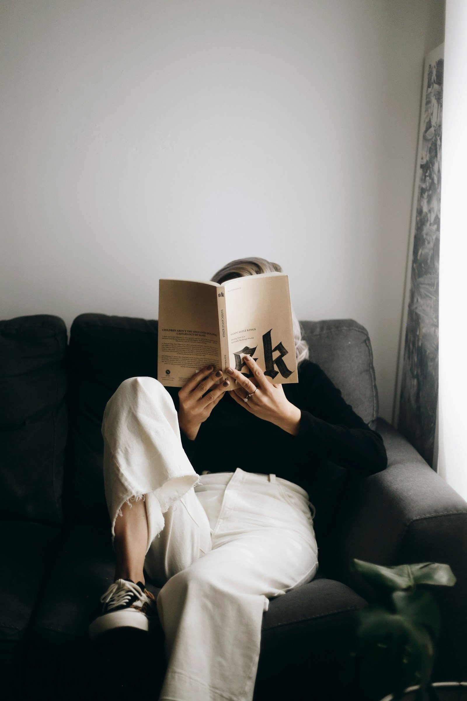 Woman reading a book on a sofa for a comfortable night in
