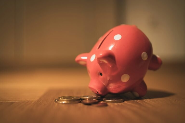 Pink piggy bank on a wooden table for building an emergency fund