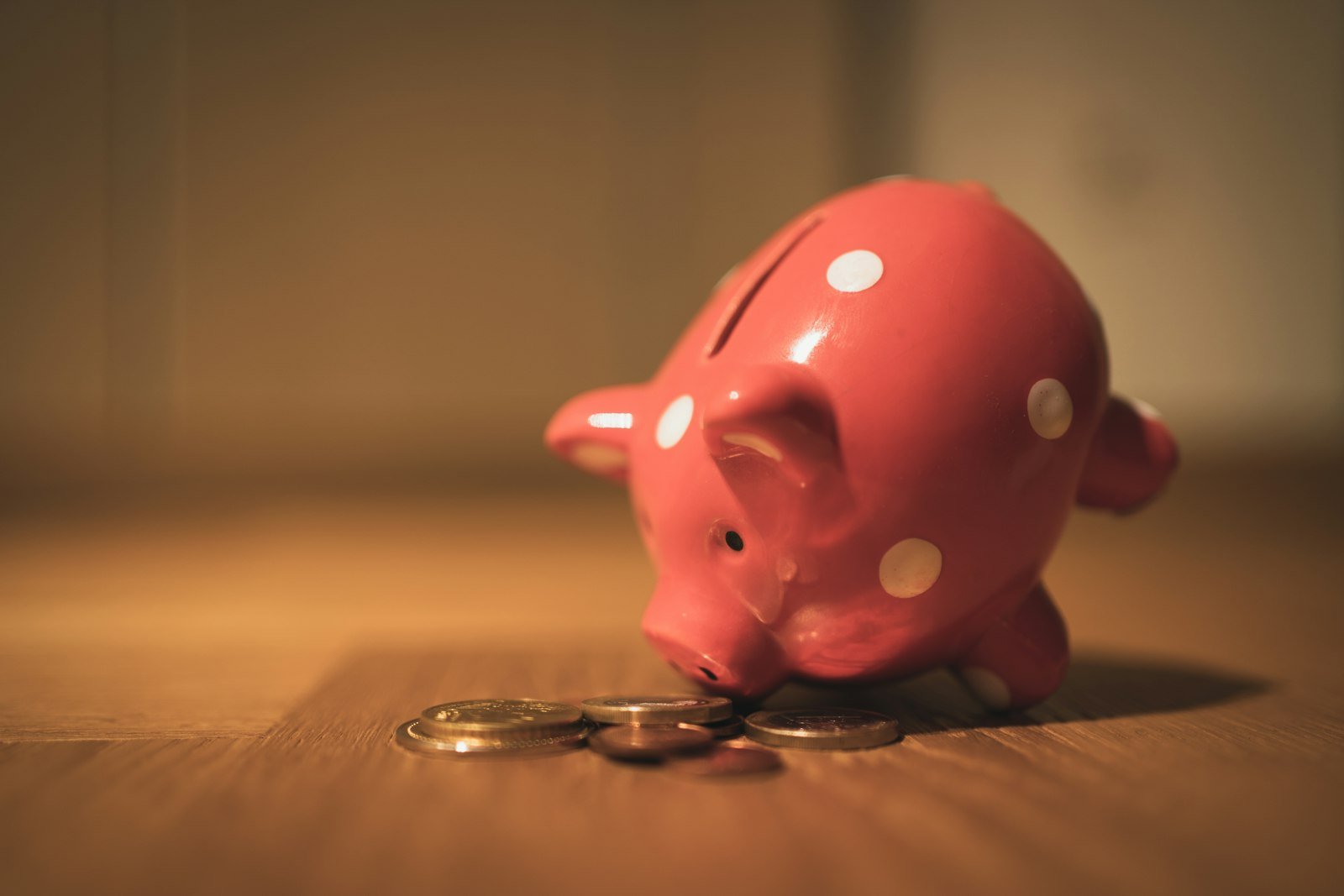 Pink piggy bank on a wooden table for building an emergency fund