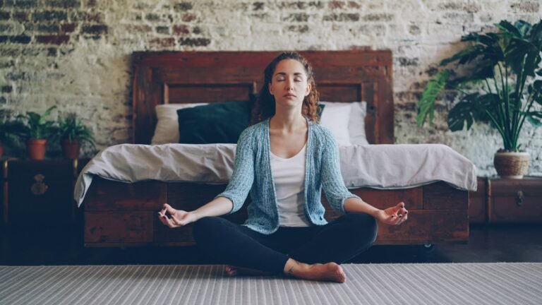 Woman meditating peacefully at home in her bedroom