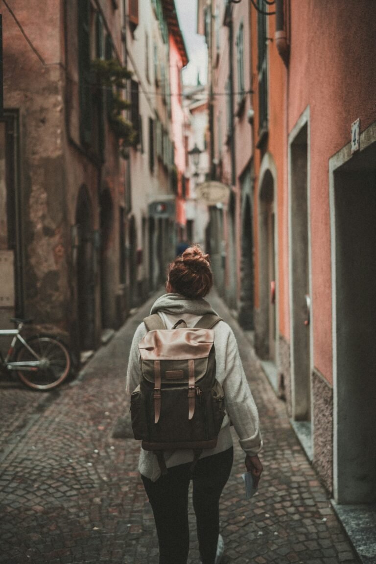 Woman travelling solo, walking down a street between buildings