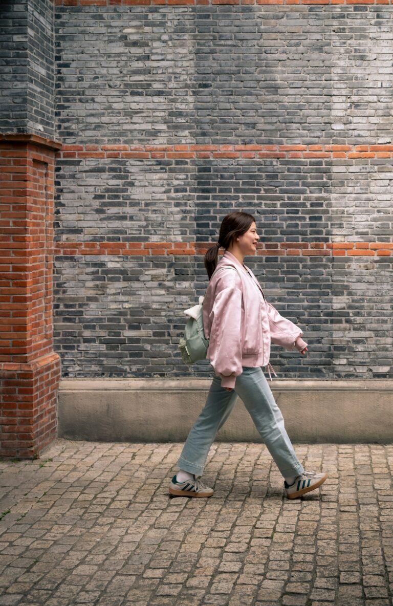 Woman walking outdoors along a brick wall as an easy workout
