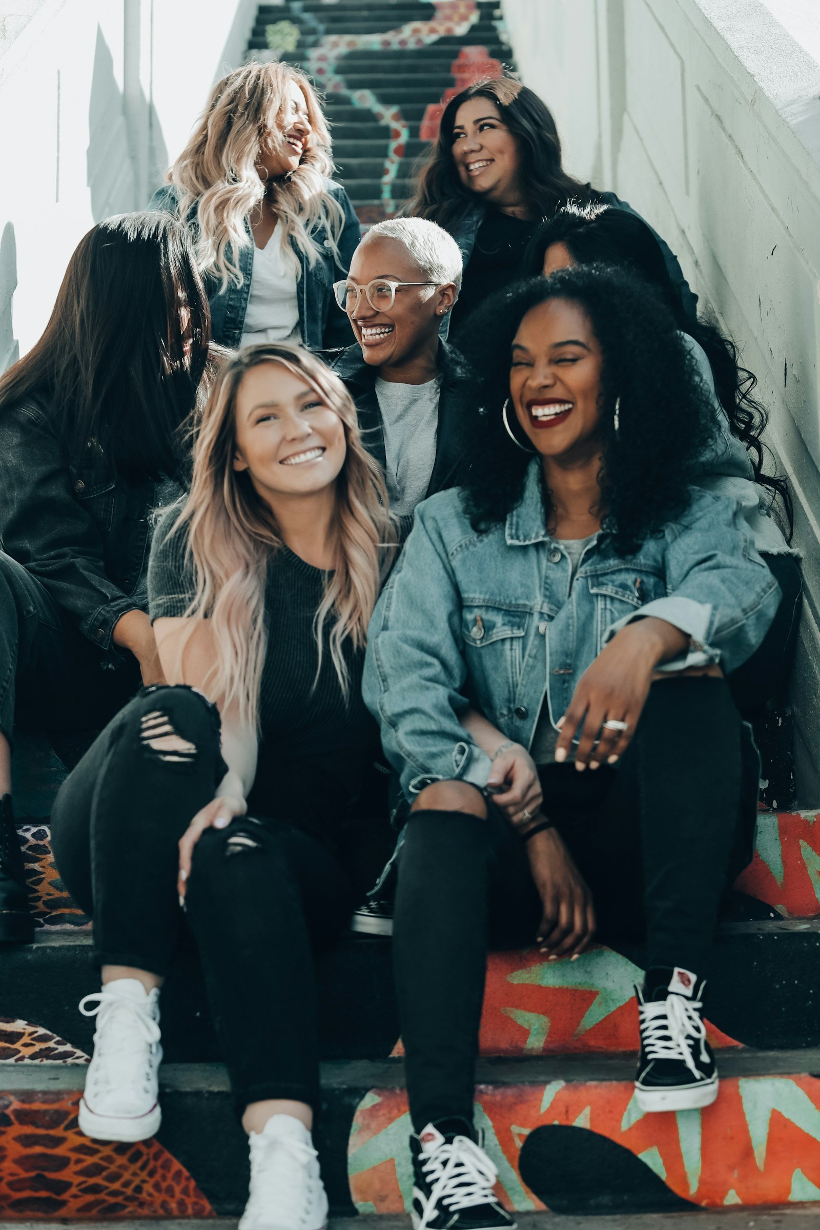 Group of women friends laughing together on outdoor stairs